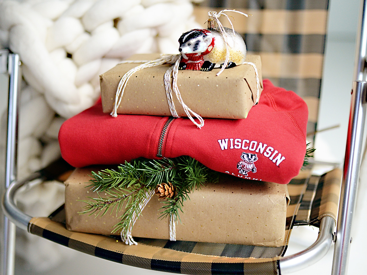 A Wisconsin zip-up is shown among wrapped packages and a badger ornament.