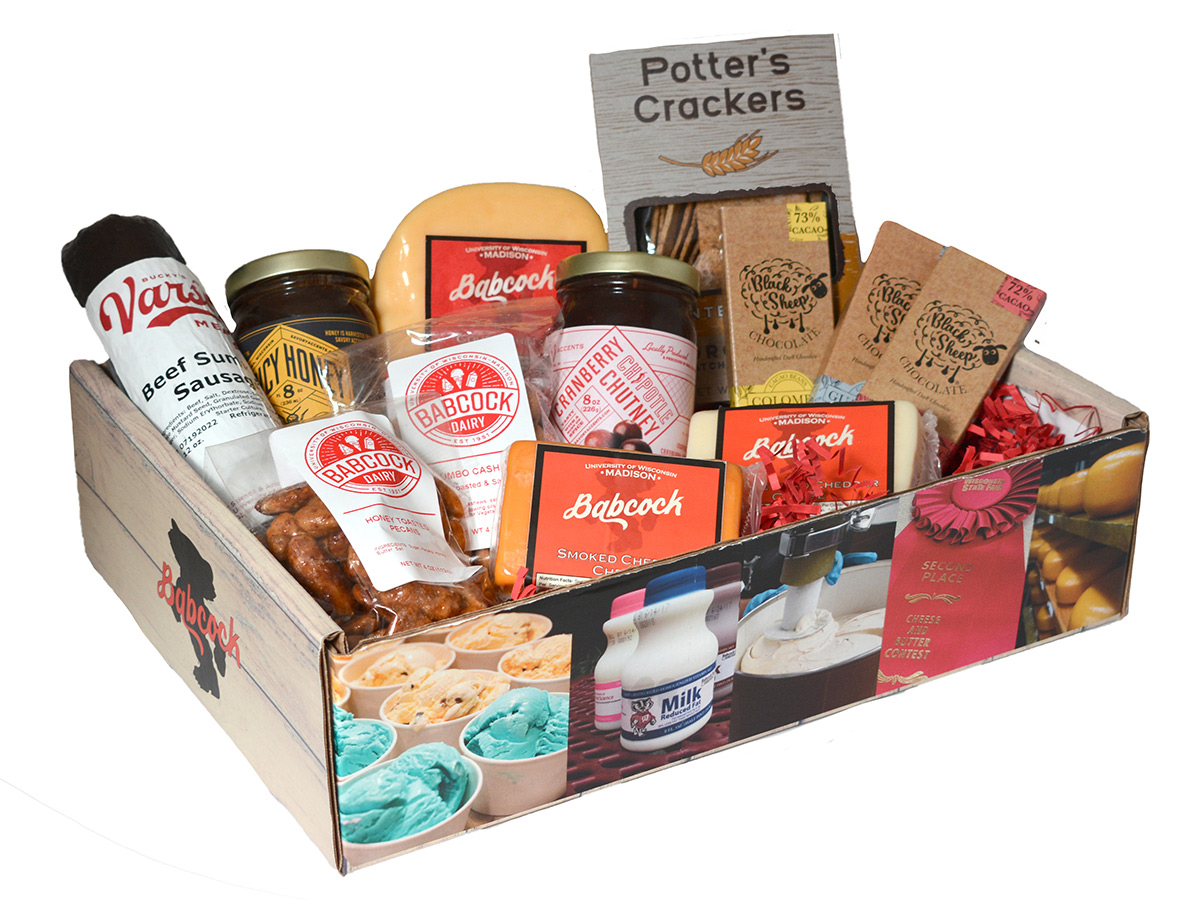 Gift box full of cheese, crackers, toasted pecans, cashews, honey, sausage, cranberry chutney and chocolate.