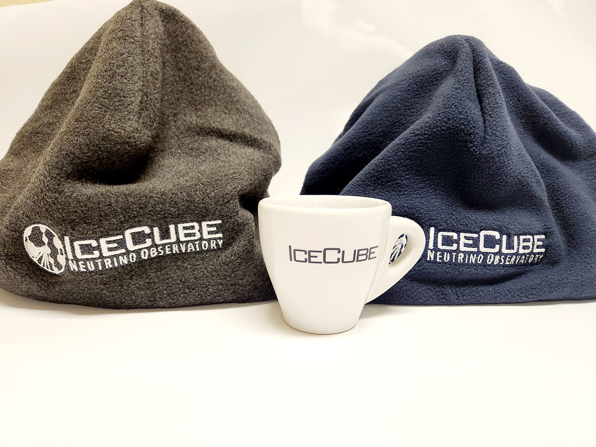Two beanies, one charcoal gray, one navy and a espresso cup are shown, all with IceCube branding.